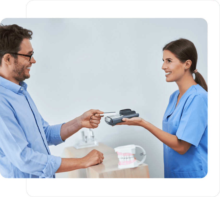 A dental receptionist taking a card payment from a patient